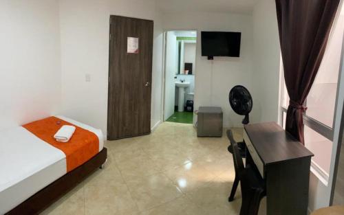 Pokój hotelowy z łóżkiem, biurkiem i pokojem w obiekcie HOTEL RAI MEDELLIN w mieście Medellín