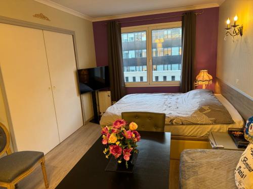 a bedroom with a bed and a table with flowers on it at ALTAMIRA (Paris Expo - Porte de Versailles) in Issy-les-Moulineaux