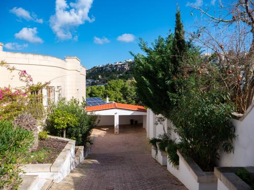 Una pasarela a través de un jardín con un edificio en Villa Alexandra - Sunset Sea Views, Heated Jacuzzi, Sauna and Gym, en Mellieħa