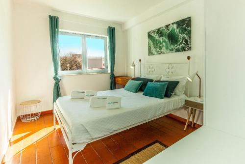 ラゴスにあるSun and Pool Apartmentの白いベッドと青い枕のある寝室