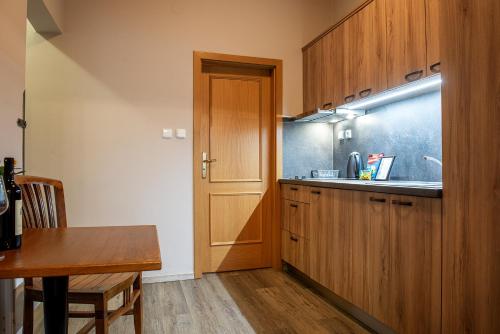 a kitchen with wooden cabinets and a wooden table at Residence Hattrick in Prague