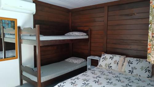 a room with two bunk beds and a bed at Pousada Sobre as Ondas - ILHA DO MEL - PR in Ilha do Mel