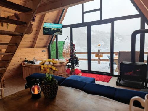 a living room with a blue couch and a large window at sataplebungalov in Çamlıhemşin