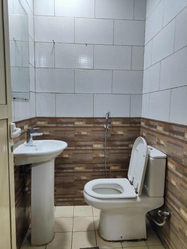 La salle de bains est pourvue de toilettes et d'un lavabo. dans l'établissement SUNSHINE BOYS HOSTEL, à Dubaï