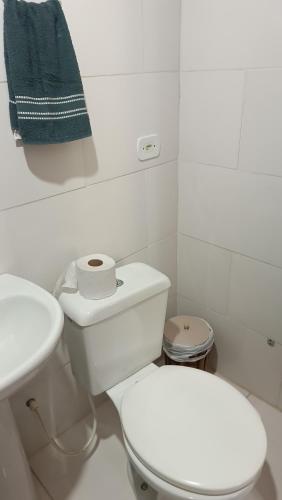 a white bathroom with a toilet and a sink at Pousada Sobre as Ondas - ILHA DO MEL - PR in Ilha do Mel
