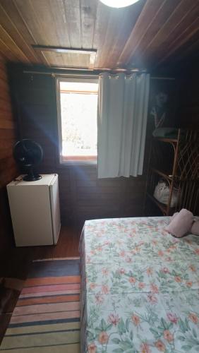 a small bedroom with a bed and a window at Pousada Sobre as Ondas - ILHA DO MEL - PR in Ilha do Mel