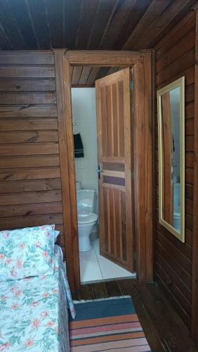 a bedroom with a bed and a bathroom with a toilet at Pousada Sobre as Ondas - ILHA DO MEL - PR in Ilha do Mel