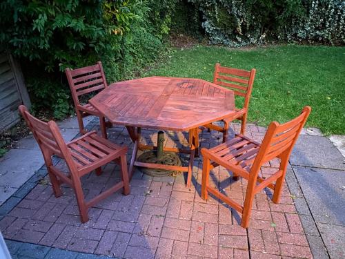 una mesa de madera y cuatro sillas sentadas a su alrededor en Cosy 3 bed detached house Birmingham, en Birmingham