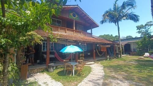 a house with a hammock in front of it at Pousada Sobre as Ondas - ILHA DO MEL - PR in Ilha do Mel