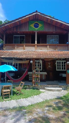a house with a hammock in front of it at Pousada Sobre as Ondas - ILHA DO MEL - PR in Ilha do Mel