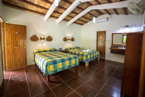 1 dormitorio con 2 camas y espejo en Hotel Cabañas Safari, en Palenque
