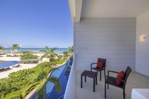 a balcony with chairs and a view of the beach at Royalton Hideaway Blue Waters, An Autograph Collection All-Inclusive Resort - Adults Only in Falmouth