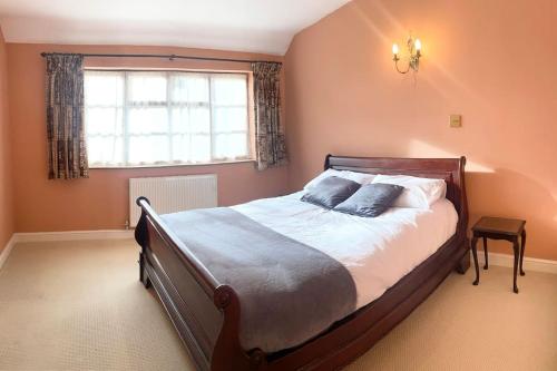 a bedroom with a large bed and a window at The wellbeing XCAPE Country Barn PT & Masseur - H in Nuneaton