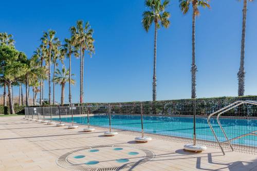 a swimming pool with palm trees in the background at H11 [Verde Giada] Piscina - Tennis - Parcheggio in Sanremo