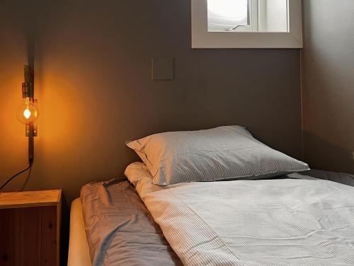 1 dormitorio con cama, lámpara y ventana en Hygge houses I Studio apartment in Lillestrøm I Solo or Couple, en Lillestrøm