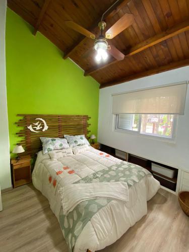 a green bedroom with a bed and a window at CABAÑA EN EL BOSQUE CENTRICA in Costa del Este