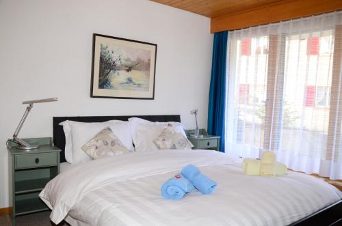 a bedroom with a bed with two stuffed animals on it at Charming and cosy apartment (sleeps 4-6 people) in a beautiful mountain village in Mürren