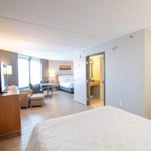 a hotel room with a bed and a living room at Holiday Inn St Louis SW - Route 66 by IHG in Saint Louis