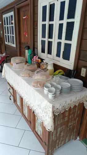 a table with dishes and plates on top of it at Pousada Sobre as Ondas - ILHA DO MEL - PR in Ilha do Mel