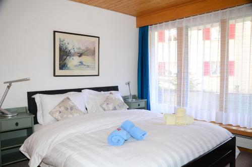 a bedroom with a bed with two stuffed animals on it at Charming and cosy apartment (sleeps 4-6 people) in a beautiful mountain village in Mürren