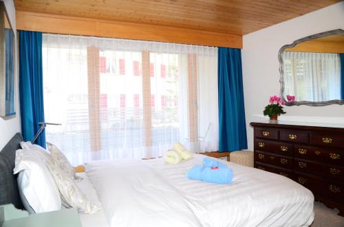 a bedroom with a white bed with blue towels on it at Charming and cosy apartment (sleeps 4-6 people) in a beautiful mountain village in Mürren