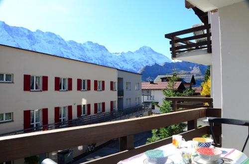 a table on a balcony with a view of mountains at Charming and cosy apartment (sleeps 4-6 people) in a beautiful mountain village in Mürren