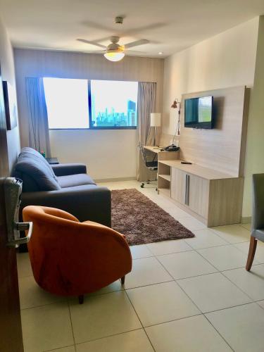 uma sala de estar com um sofá e uma televisão em Beach Class Convention - Boa Viagem no Recife