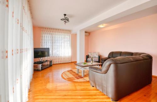 a living room with a couch and a television at Villa Makeli in Rogachevo