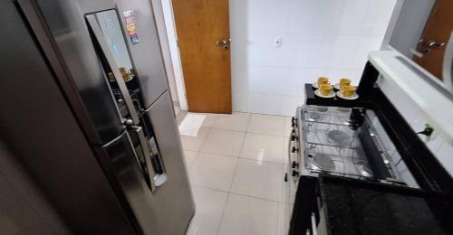 a kitchen with a refrigerator and a tile floor at LINDO APT 3q FRENTE A PRAIA in Guarapari
