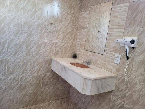 een badkamer met een wastafel en een spiegel bij Solarium Park Hotel in Adamantina
