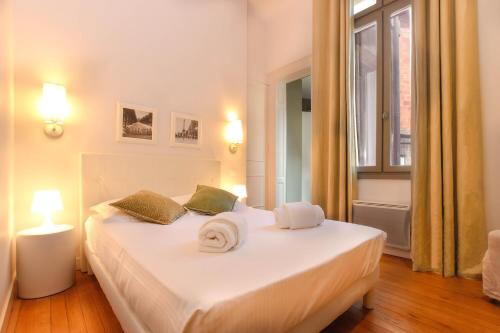 a bedroom with a white bed with towels on it at Magnifique et lumineux T3 de charme aux Quinconces idéal pour 4 personnes in Bordeaux