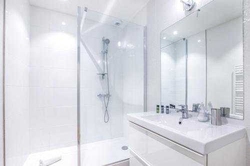 a white bathroom with a sink and a shower at Magnifique et lumineux T3 de charme aux Quinconces idéal pour 4 personnes in Bordeaux