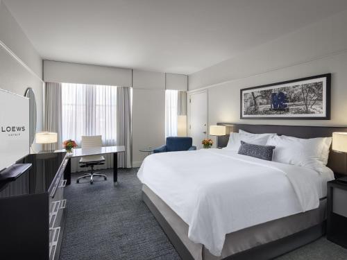 um quarto de hotel com uma cama grande e uma secretária em Loews Philadelphia Hotel em Filadélfia