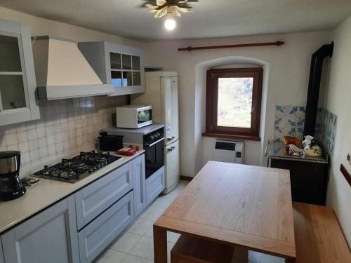 eine Küche mit weißen Geräten und einem Holztisch in der Unterkunft Dolomia in Villagrande