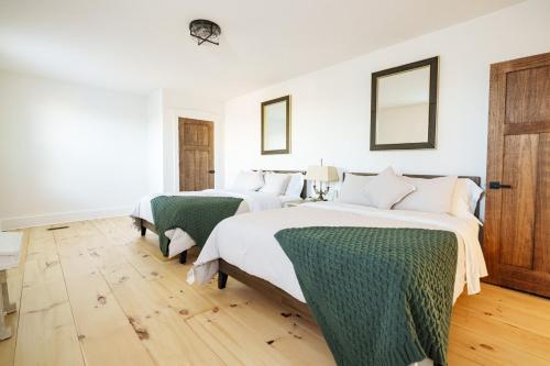 2 letti in una camera da letto con pareti bianche e pavimenti in legno di Very Comfy Farmhouse Apartment Unit A, 1st FL a Lancaster