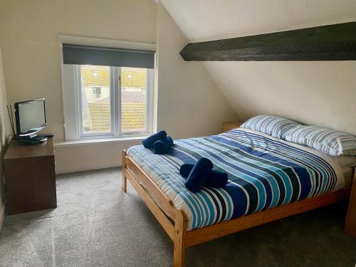 een slaapkamer met een bed met twee knuffels erop bij Aisha’s Attic in Rhyl
