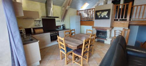 une cuisine avec une table en bois et une cheminée dans l'établissement Maison de vacances vue panoramique le Pailler 4 à 9 personnes, à Millau