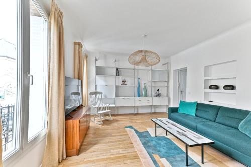 un salon avec un canapé et une table dans l'établissement Sublime 2P à 15 min du centre de Paris., à Courbevoie