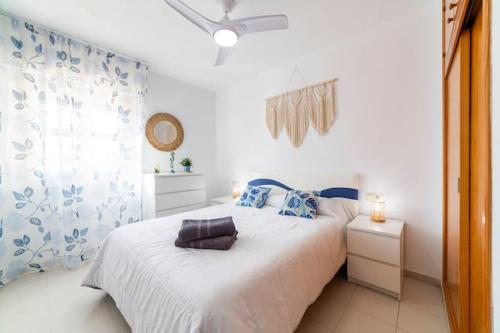 ein Schlafzimmer mit einem weißen Bett mit blauen und weißen Vorhängen in der Unterkunft Apartº Roquetas de Mar 1º linea playa in Roquetas de Mar