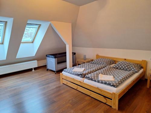 a bedroom with a bed and a dresser and two windows at Apartmány Paseky - Jablonec nad Nisou in Jablonec nad Nisou