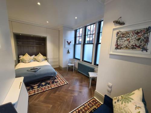 a bedroom with a bed and a large window at New Boutique Ground Floor Apartment in London