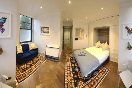 a bedroom with a large bed and a couch at New Boutique Ground Floor Apartment in London