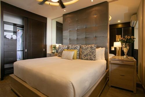 a bedroom with a large bed with a large headboard at Pinnacle Resorts in Puerto Vallarta