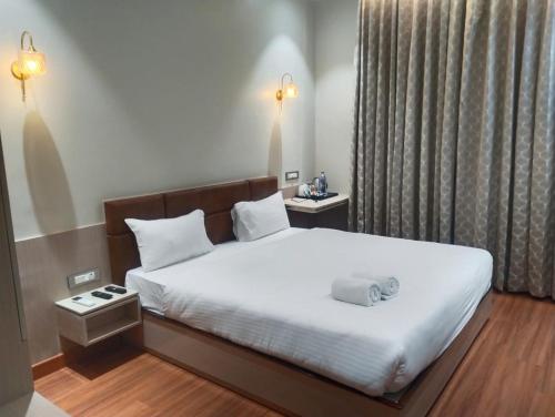 1 dormitorio con 1 cama con sábanas blancas y almohadas blancas en Buddha Stays, en Varanasi