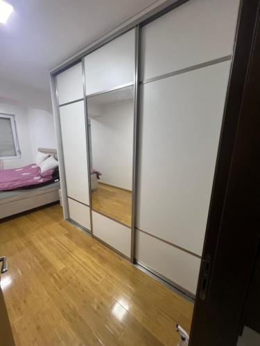 Habitación con puertas correderas de cristal y cama en Downtown Apartment, en Strumica