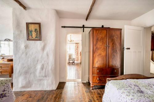 a bedroom with a wooden cabinet and a bed at Rosehill House in Dungannon