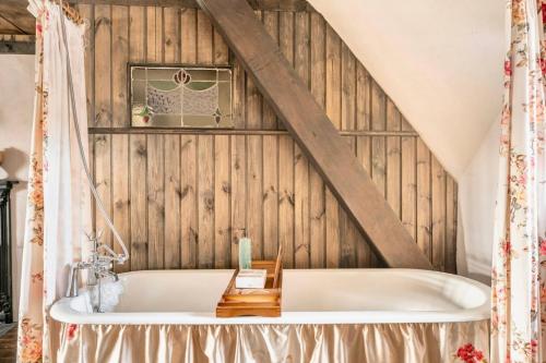 a bath tub in a room with a wooden wall at Rosehill House in Dungannon