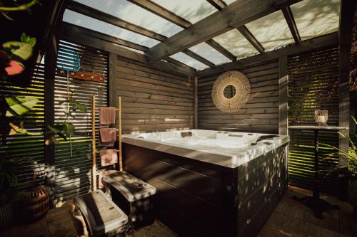 uma casa de banho com uma grande banheira num quarto com janelas em Apart House Karwia & Wellness em Karwia