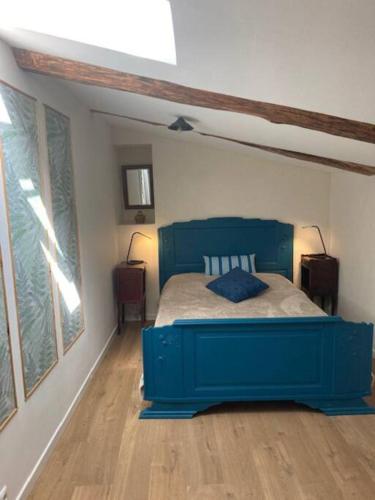 - une chambre avec un lit bleu dans l'établissement Le grenier du Vissou, à Cabrières