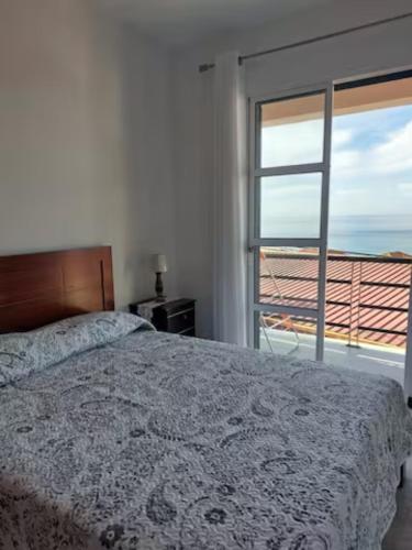 a bedroom with a bed and a view of the ocean at Barbara Home in Madalena do Mar